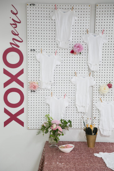 Sweet XOXO Baby Shower, backdrop with onesies hanging