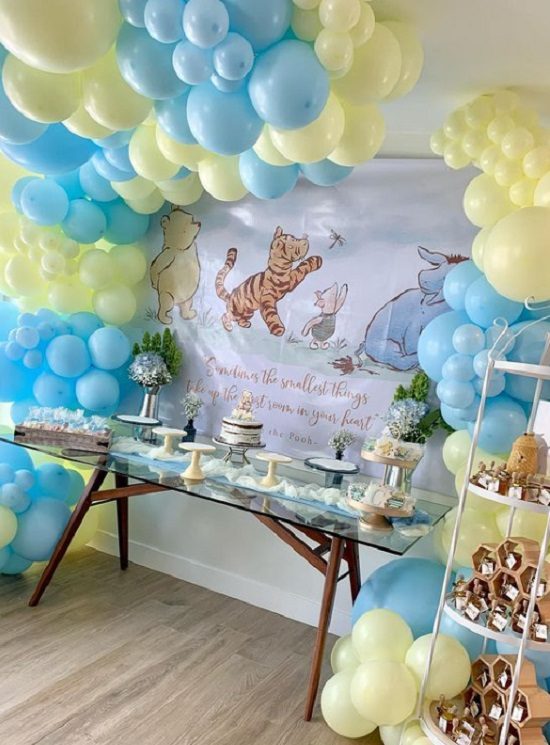 pooh bear baby shower dessert table and backdrop balloons