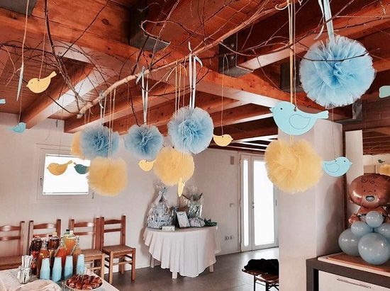 bird cutouts and poms hanging down a branch